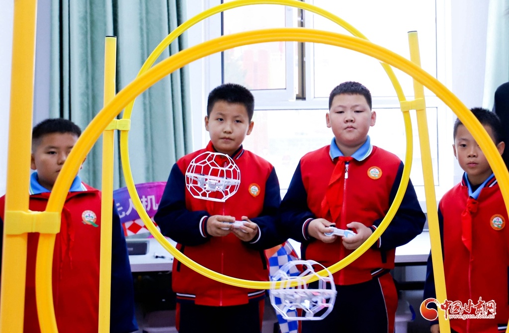 10月13日,张掖市高台县国庆小学无人机课堂内,同学们在进行无人机对抗赛。