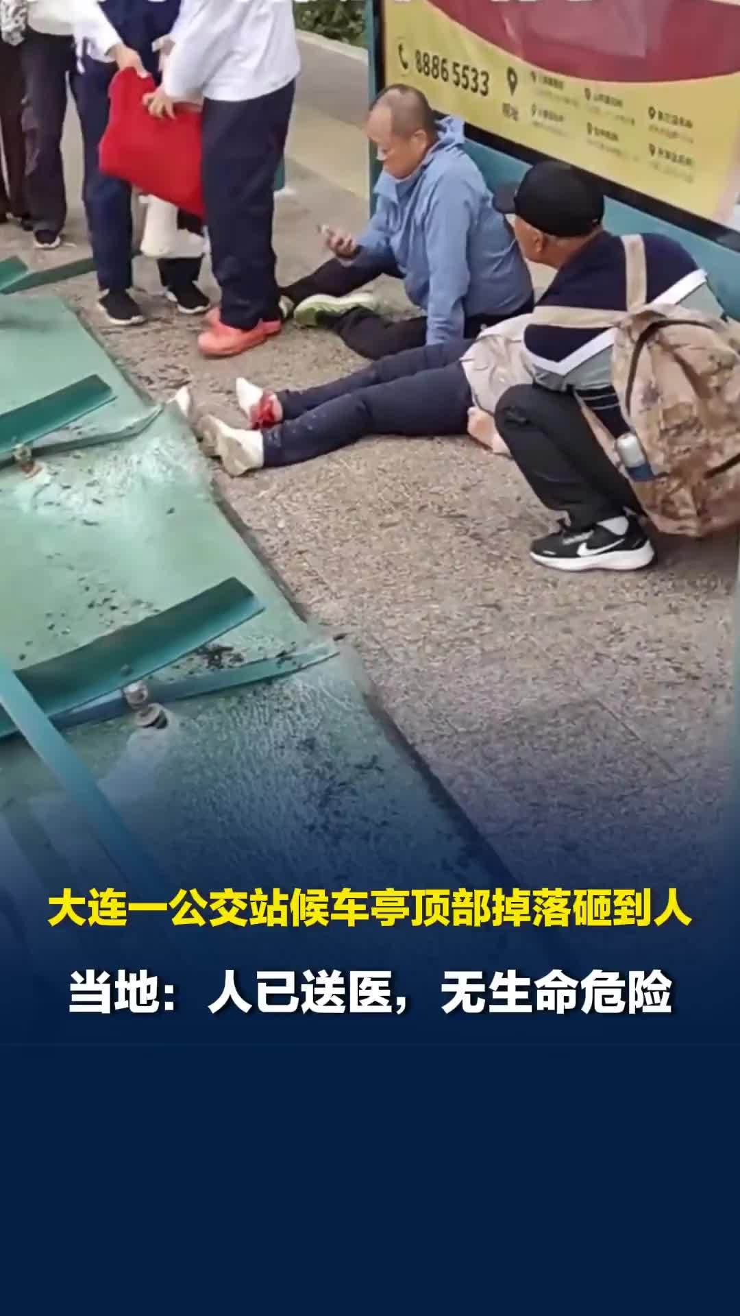 大连一公交站候车亭顶部掉落砸到人，有一人平躺在地上没有动静，当地回应
