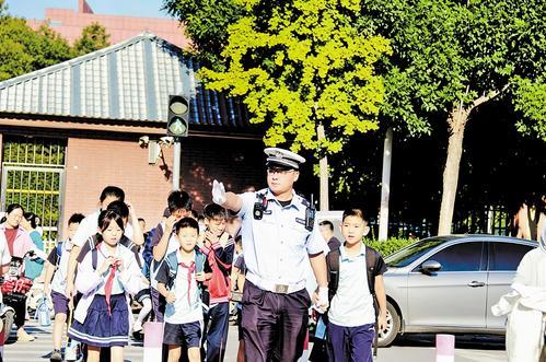 9月1日，在沧州市迎宾小学西门外的永安大道，执勤民警护送小学生安全通过人行道。