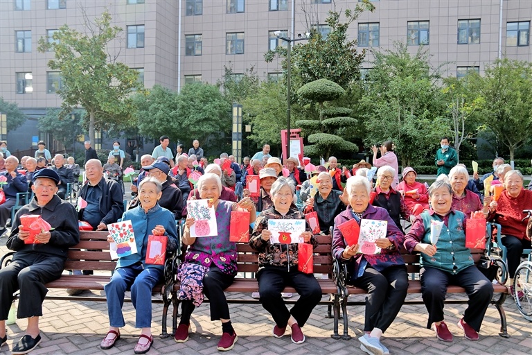 10月15日,许昌市怡康苑护理院举行“九九重阳情 浓浓敬老心”活动,老人们收到了幼儿园小朋友赠送的手工礼物,露出幸福的笑容。 炊金钊 摄