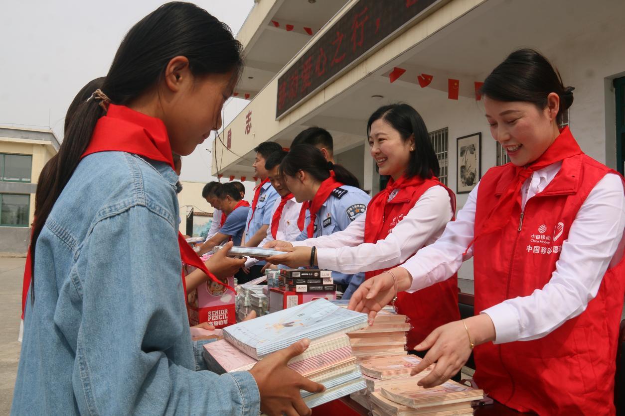 (志愿者们在学校分发学习资料)