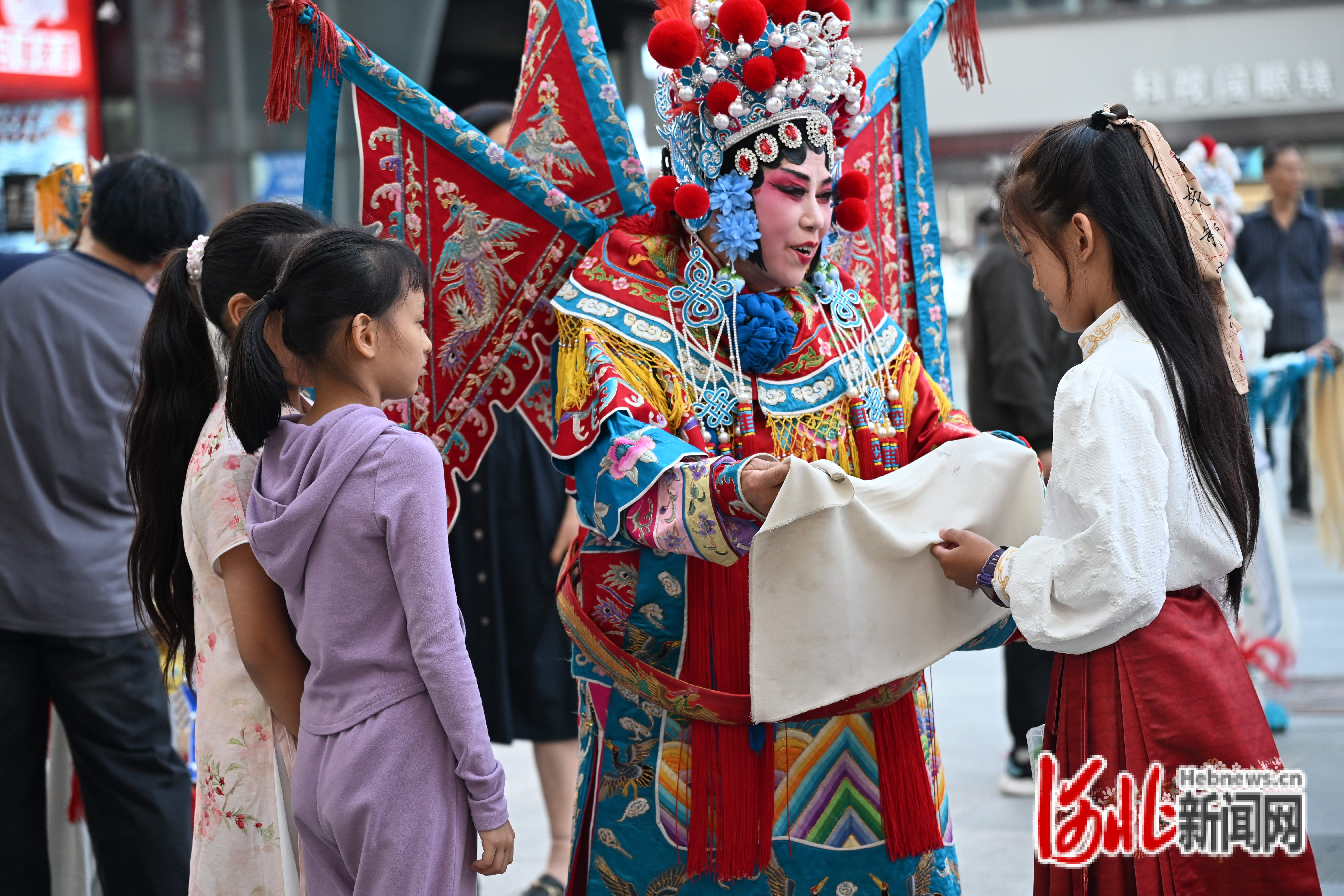 戏曲演员与现场青少年观众亲切互动，近距离感受戏曲服饰与国粹魅力。