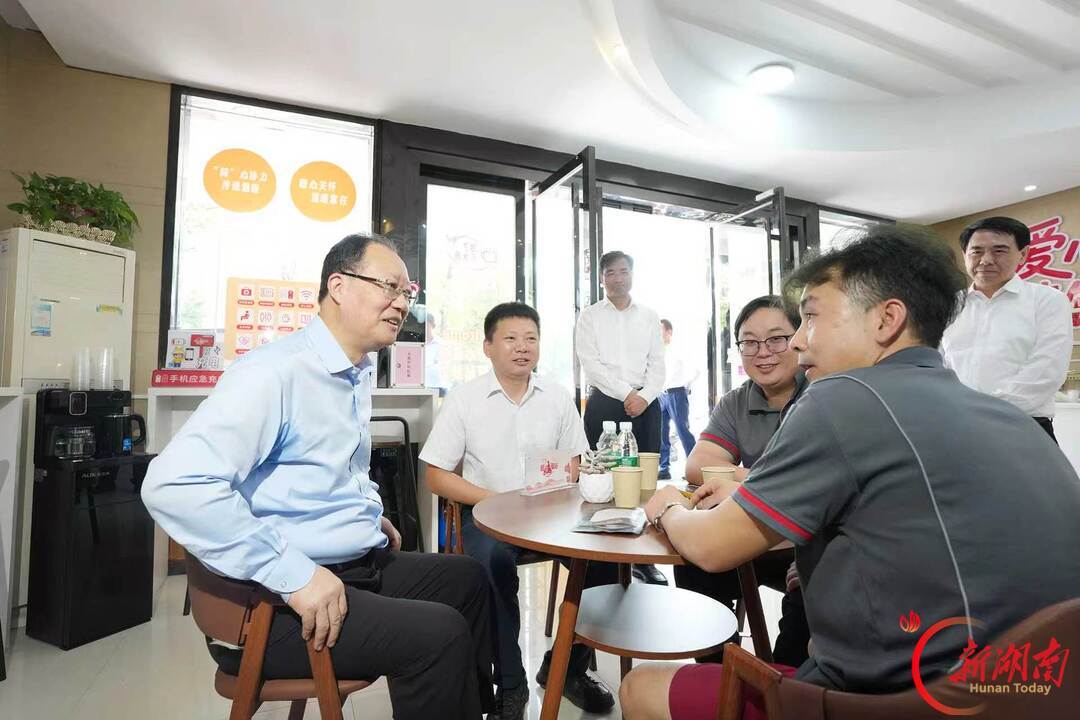 毛伟明与快递小哥交流。