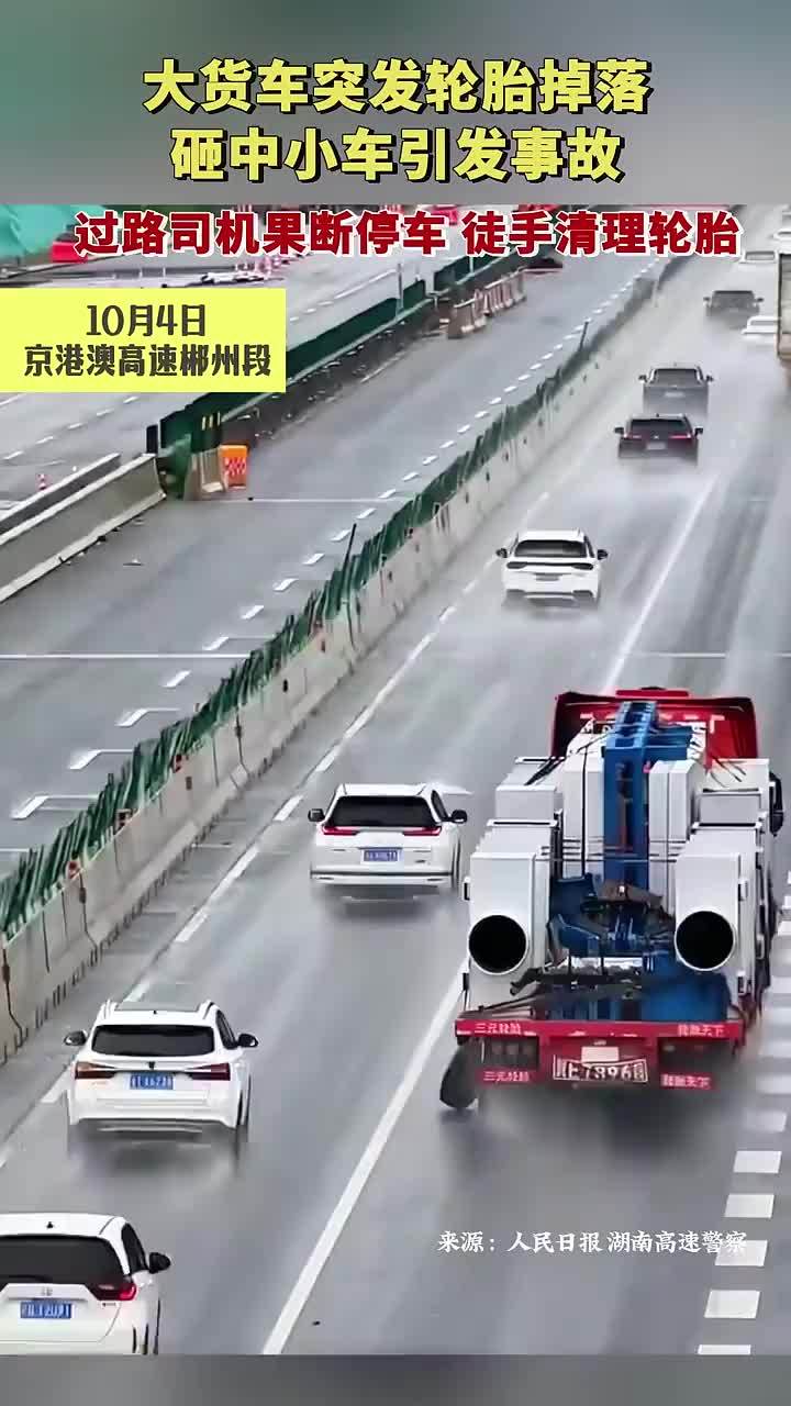 大货车突发轮胎掉落砸中小车引发事故，过路司机果断停车徒手清理轮胎