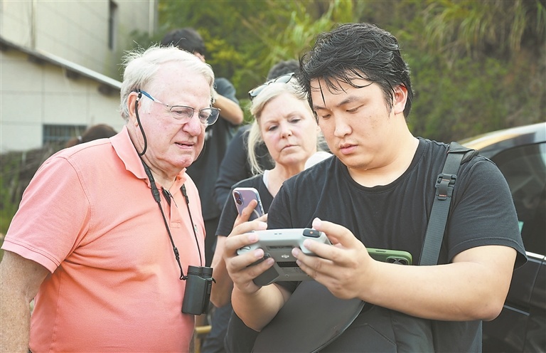 江西日报记者陆文青（右一）用无人机进行航拍，帮助杜立特突袭者后人确认第14号机坠落点。江西日报全媒体记者 吴文兵摄