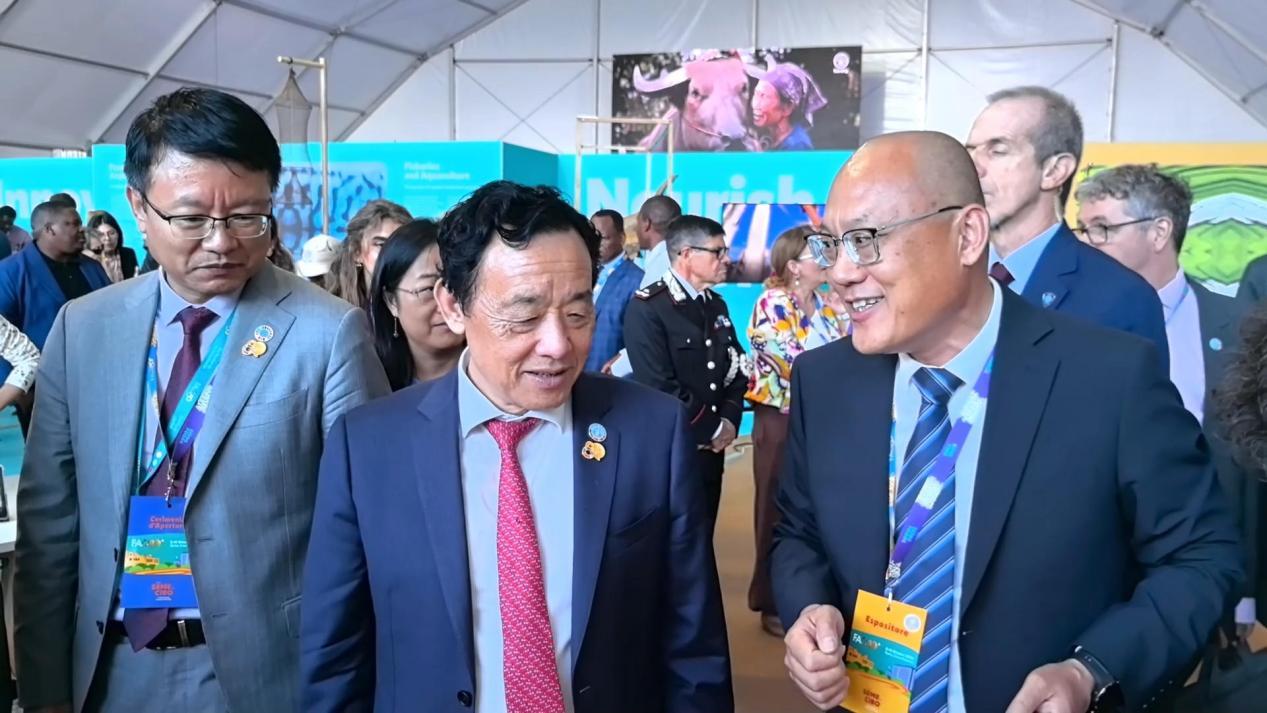 联合国粮农组织总干事屈冬玉(中)莅临金丰公社展位指导交流