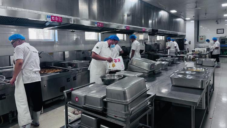 水城中学食堂工作人员正在备菜炒菜