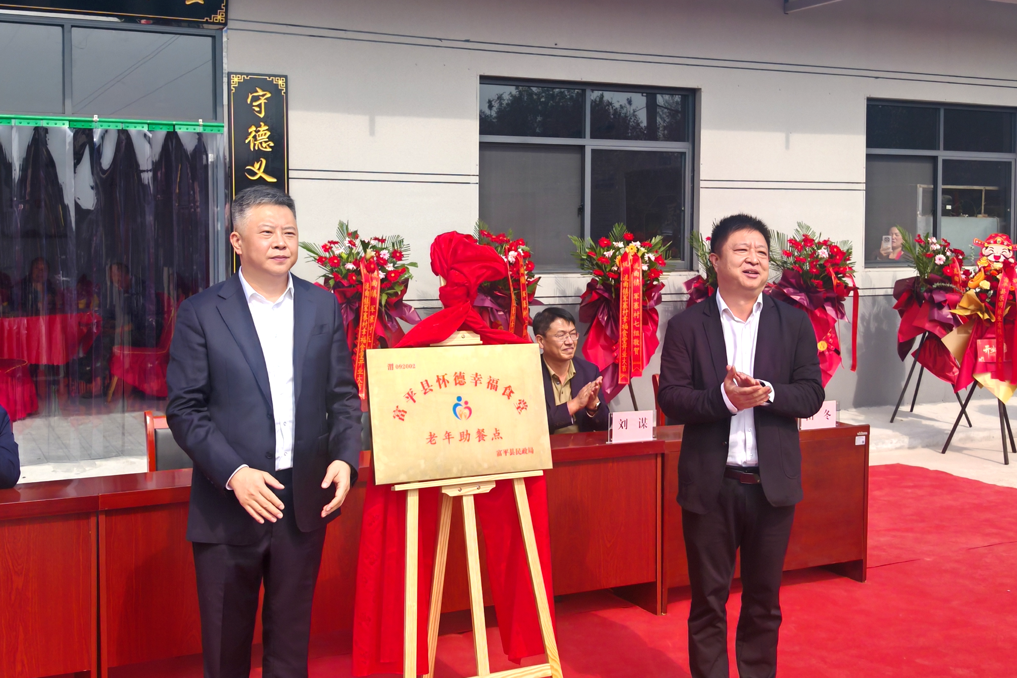 县政府副县长艾路阳与镇党委书记田晓雷共同为军寨村幸福大食堂揭牌