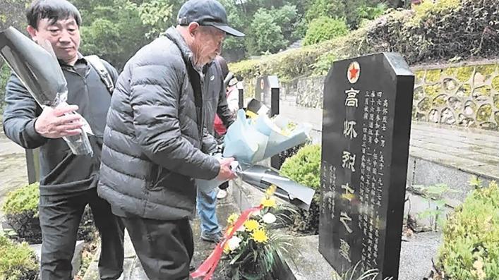 高洪臣（左二）在父亲墓前献上鲜花 通讯员供图