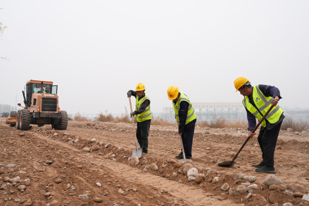 10月12日，涿州市北拒马河调蓄工程施工现场，建设者正在进行巡河路路基找平作业。