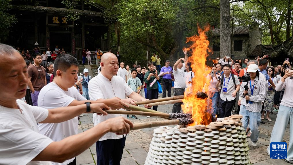 10月19日，在馒头窑的点火仪式上，古窑民俗博览区的制瓷师傅点燃火把。新华社记者 胡晨欢摄