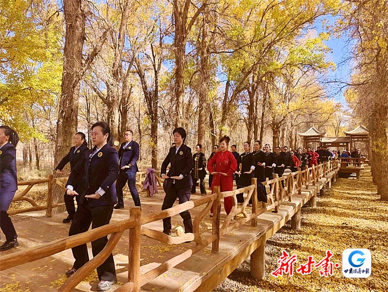 运动员们在金塔沙漠胡杨林景区展示八段锦健身气功
