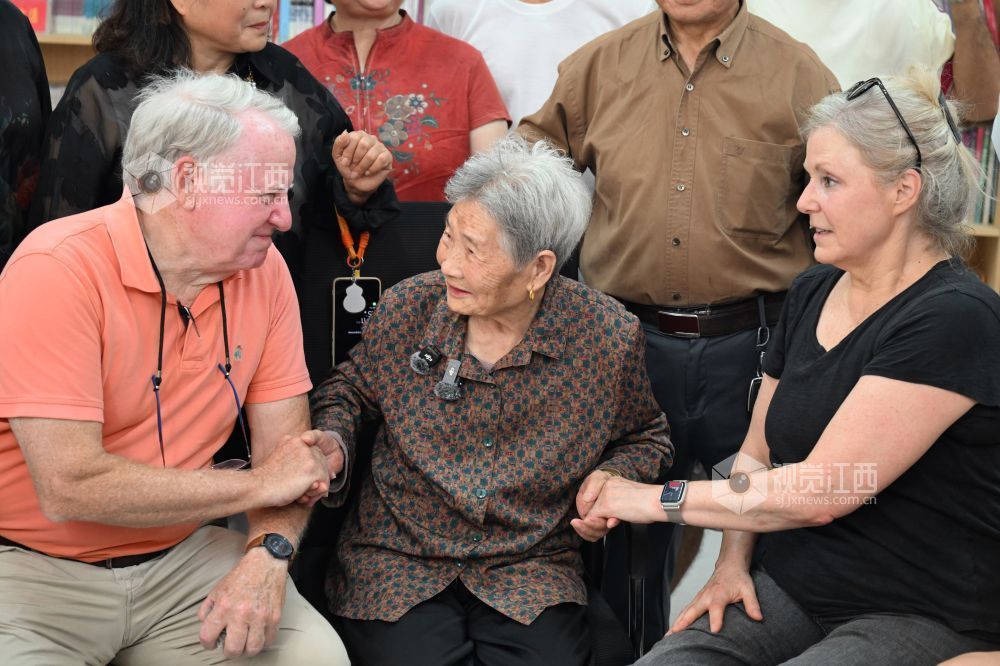 10月11日，上饶市广丰区杨村村委会，托马斯&middot;马西亚（左）与金伯利&middot;约翰逊紧紧握住亲历救援的村民官冬香（中），向她连连道谢。