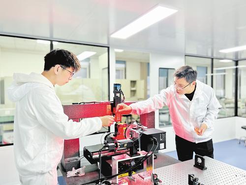 10月19日，在河北工业大学创新研究院（石家庄）半导体材料与器件激光高精密加工实验室，来自学校电子信息工程学院的青年教师张朕（右）和学生正在查看激光加工工艺流程。李东杞摄