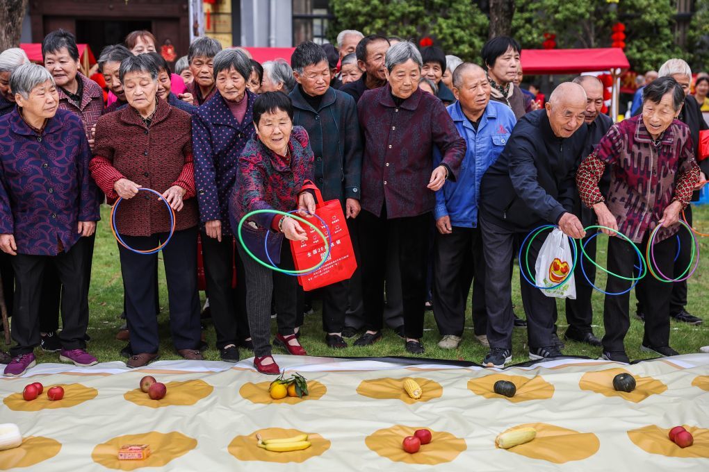老人们在浙江省杭州市临平区塘栖镇河西埭村重阳孝心节上参加套圈游戏。新华社记者 徐昱 摄