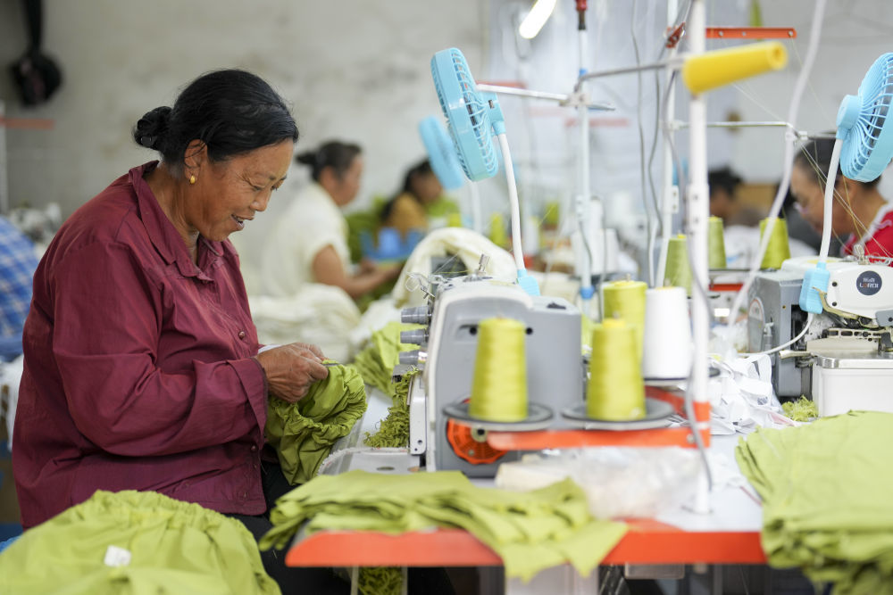 在重庆市綦江区安稳镇崇河村一家服装厂内,村民利用农闲时间在这里就近务工。新华社记者 刘潺 摄