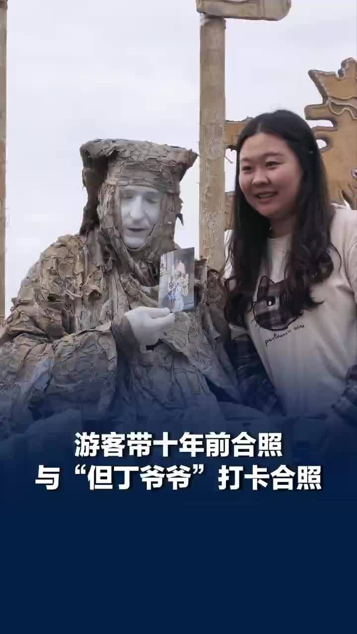 游客带十年前合照与但丁爷爷合照，但丁爷爷收下十年前合照放进箱子