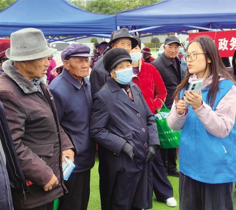工作人员向市民介绍线上办理事务流程