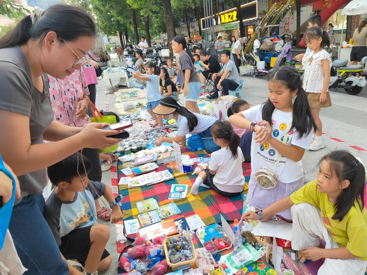 小摊主们正热情地向顾客推介摊位物品
