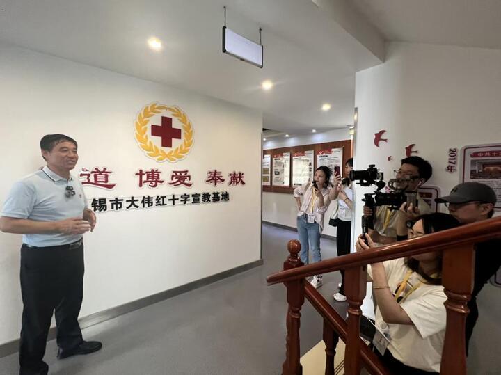 苏大伟（左一）带领采访团成员们参观苏大伟志愿文化馆