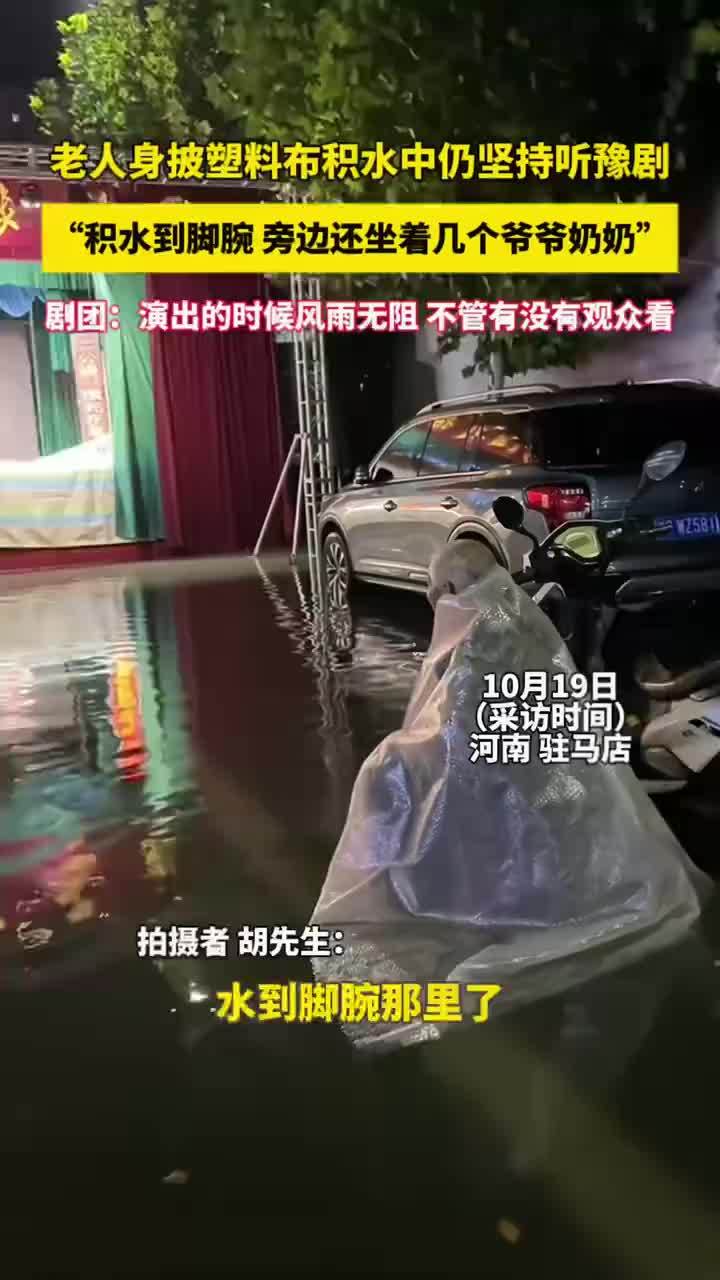 老人身披塑料布积水中坚持听豫剧
