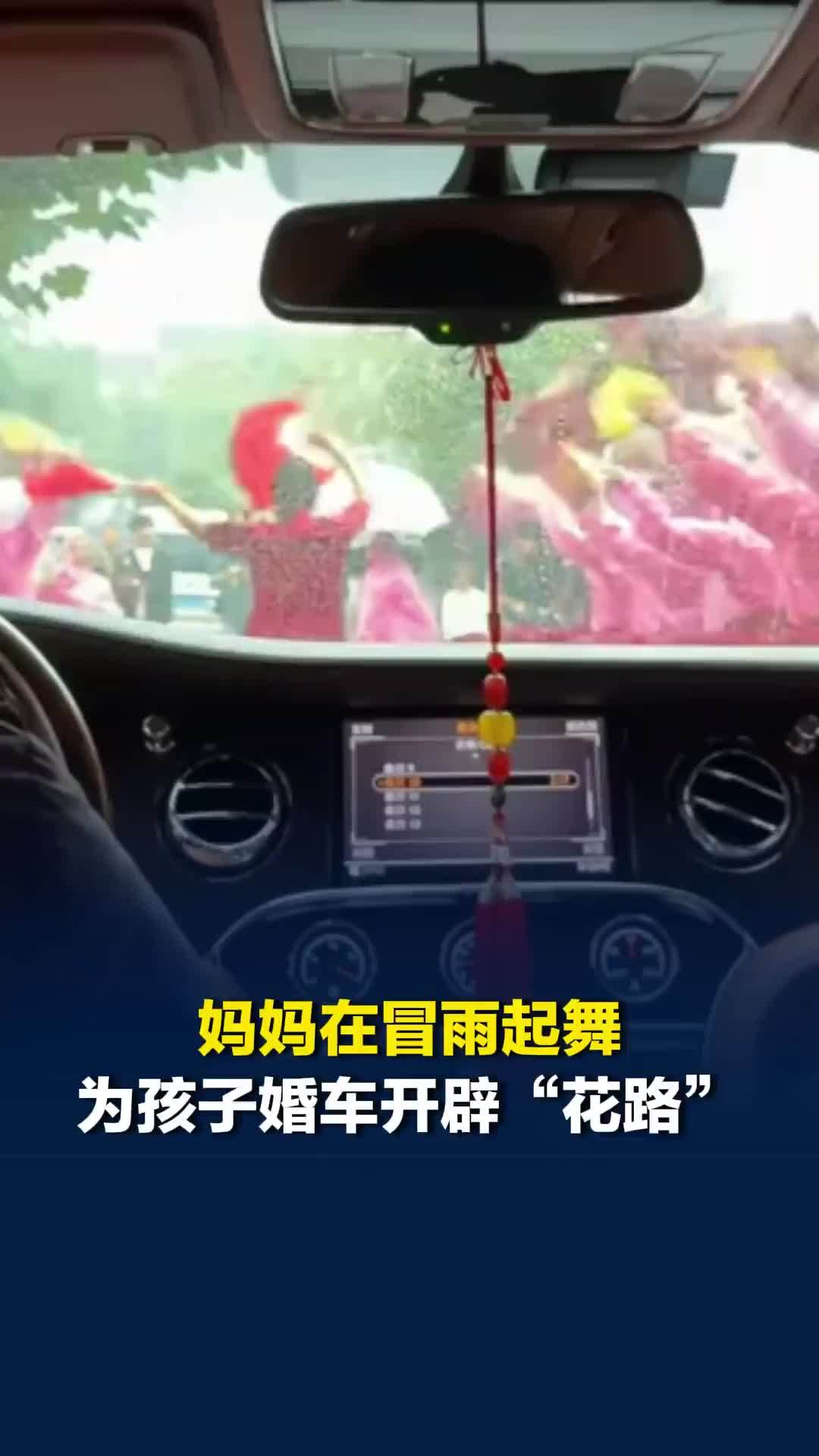 妈妈在孩子婚礼当天冒雨起舞，为婚车开辟“花路”