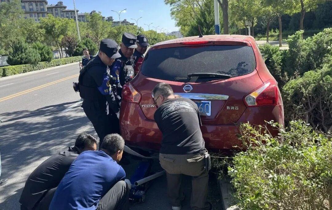 △图为街面警务站民辅警与市民携手,把误入绿化带的车辆挪出,快速处置险情。