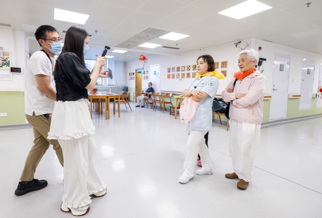 2026年8月11日，在浙江省湖州市蜀山养护院内，护士沈婉婷（右二）与老人一起拍摄短视频。这家养老院内的老人因年岁较高，日常谈话交流时常出现听错、误解等情景，容易带来反差甚至搞笑的戏剧效果。受到启发，沈婉婷和同事决定通过镜头展现老有所养、老有所乐的银龄生活，陆续推出《蜀山二三事》《银龄小剧场》《湖州话等级考试》等一系列衍生短视频作品。新华社发（伊凡　摄）