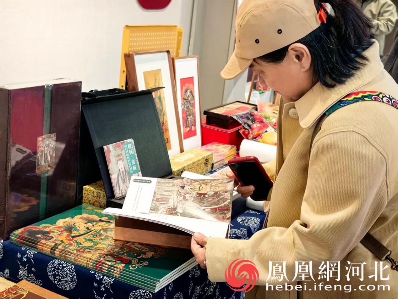 参观者翻阅毗卢寺壁画文创画册