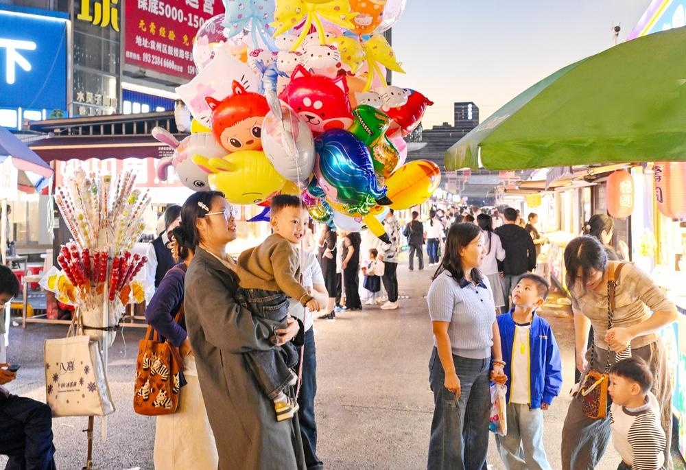 宜春中心城区夜市热闹非凡，市民与游客在夜市品尝美食，感受浓浓烟火气。图为鼓楼夜市游人如织。 （记者 易志钟 摄）