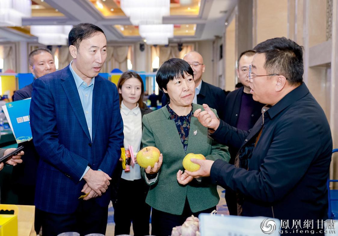 甘肃省供销联社理事会副主任王宁梅(前中)与新疆维吾尔自治区供销联社理事会副主任达列力别克·坎加汗(前左)了解参展的特色农产品 甘肃省供销联社供图