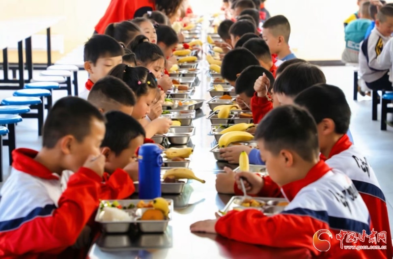 武威市凉州区黄羊实验小学学生吃得津津有味(郑芃生 摄)