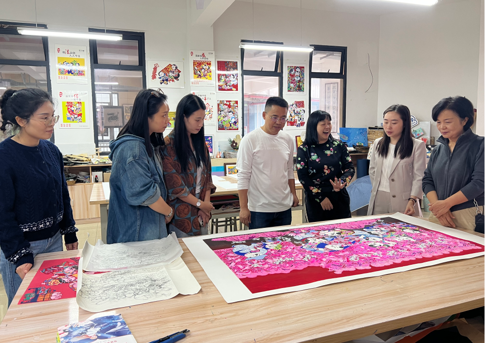 9月26日,在梁平泰和小学,梁平区文化遗产保护中心主任查看即将到新疆展出的梁平年画。梁平区文化遗产保护中心供图