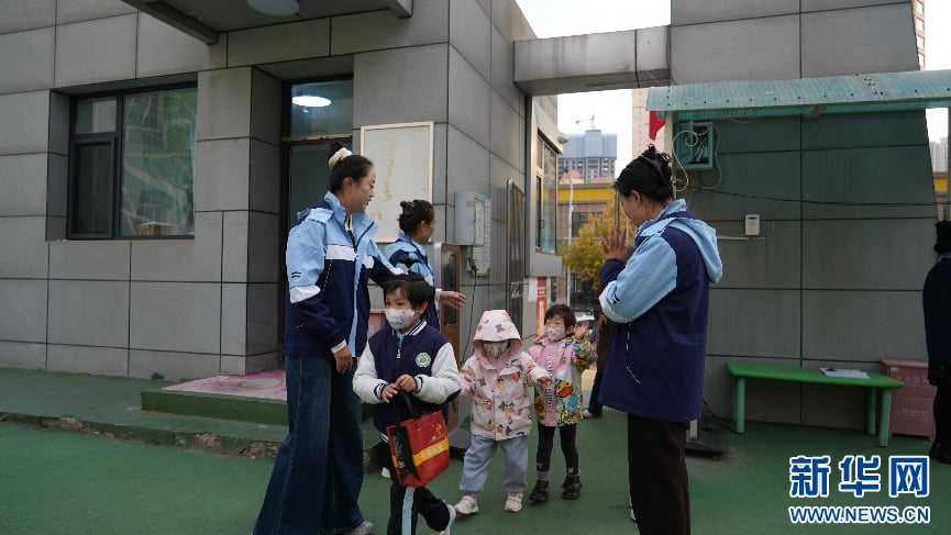 图为临夏市幼儿园的老师们迎接到校的小朋友
