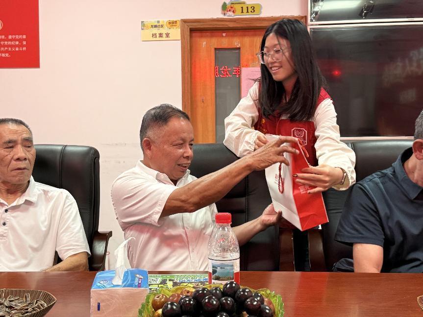 座谈会合照(左);社区向退役军人赠送保温杯(右)。