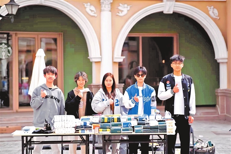 郑州西亚斯学院组织多场AI普及培训,鼓励学生创业。图为沈威(左一)与同学在校内创业时的合影。受访者供图