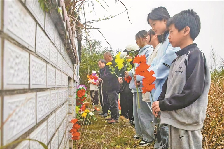 彭家人向墓碑献花。