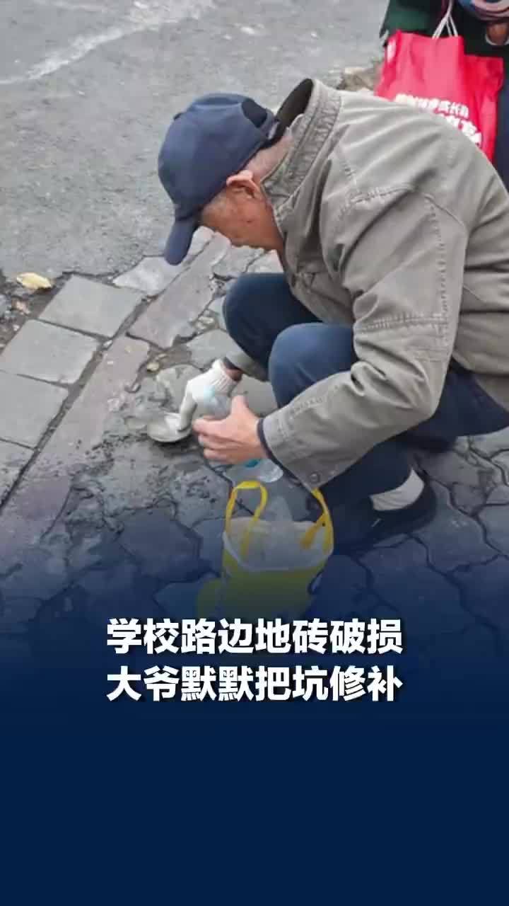 学校地砖破损大爷默默修补