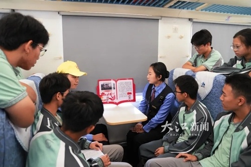 赣州中学学生正在聆听列车工作人员讲解红色故事