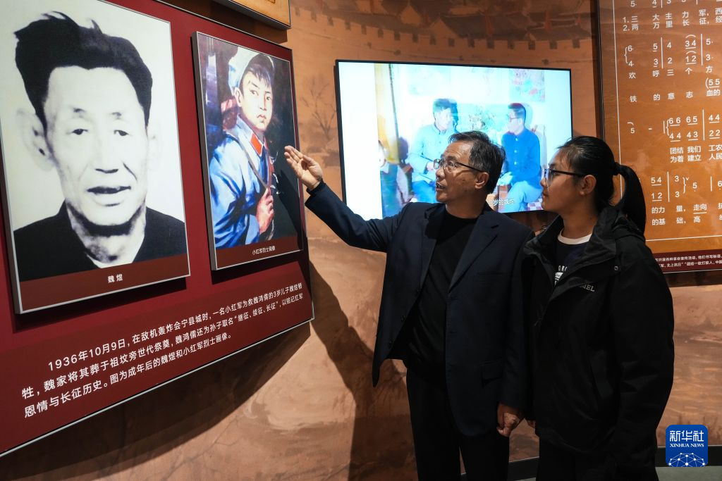 10月16日,在会宁长征胜利纪念馆,王新胜向侄孙女王萌讲述小红军救魏煜的故事。新华社记者 郎兵兵 摄