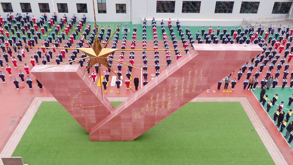 10月26日,在甘肃省定西市通渭县文庙街小学的《七律·长征》诗碑下,学生集体朗诵《七律·长征》(无人机照片)。新华社发(王克贤 摄)