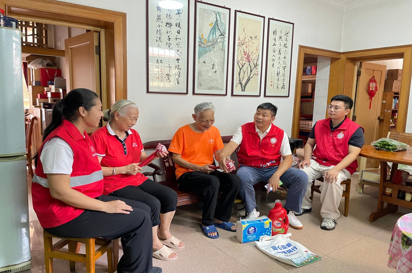 志愿者参与艾草锤手工制作(左),入户与长者交流并送上关怀(右)。