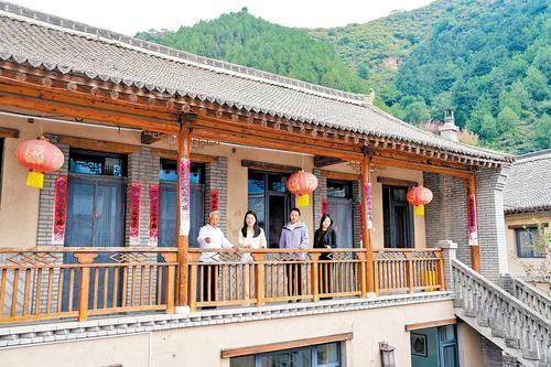 近日,骆驼湾村村民在自家民宿向游客介绍骆驼湾村的变化。本报记者 许佳奇摄