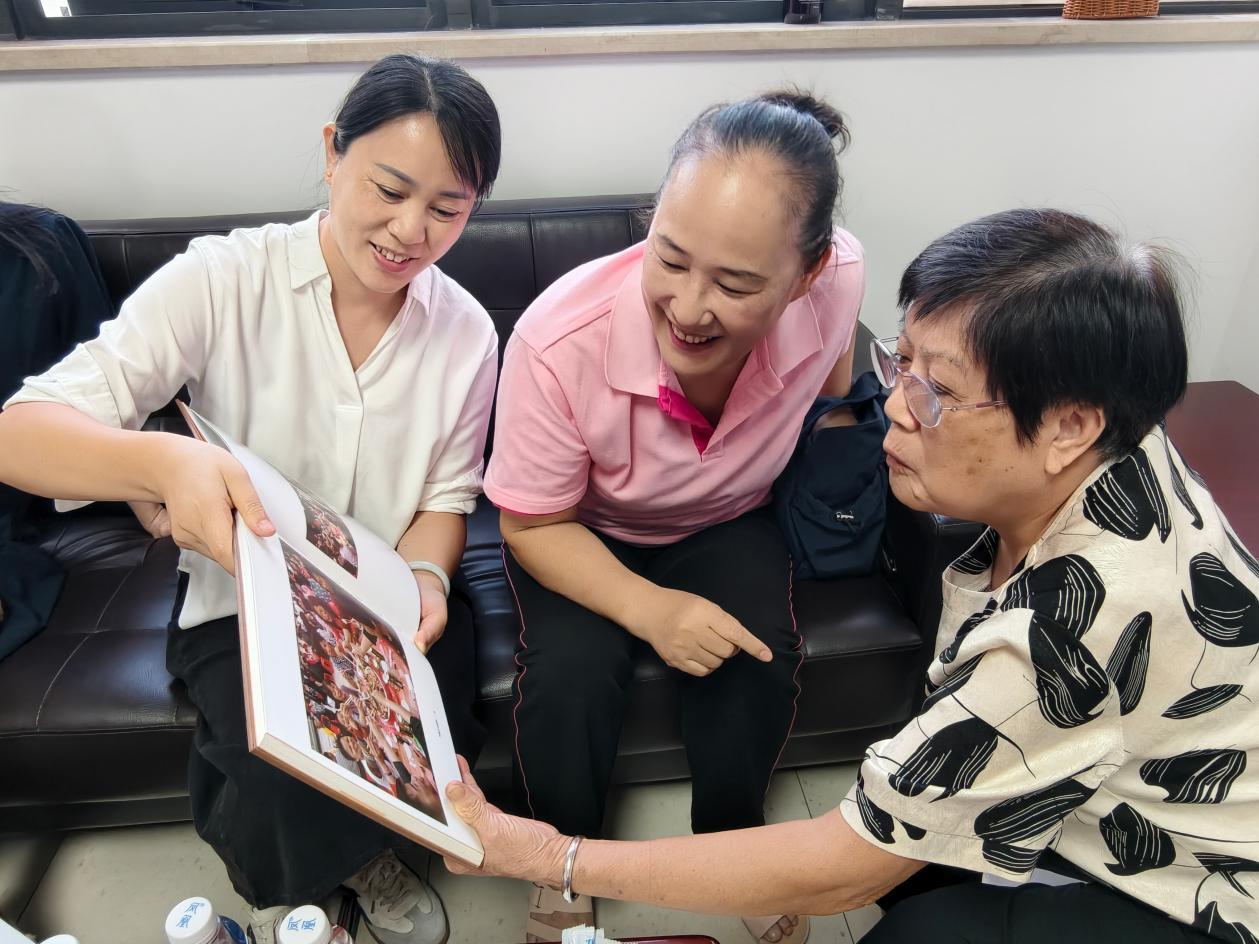 座谈中,街坊翻看相册,交流北帝三月三庙会的往事。
