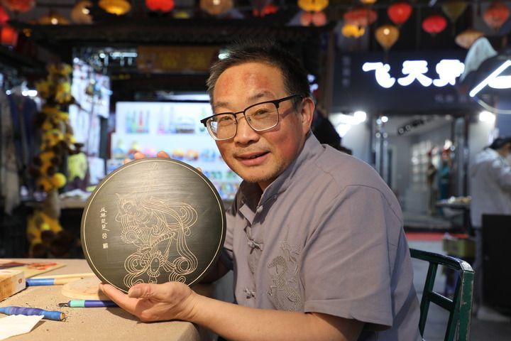 敦煌木雕画代表性传承人申洪杰在工作室展示木雕画作品《反弹琵琶》 新华社记者 张智敏 摄