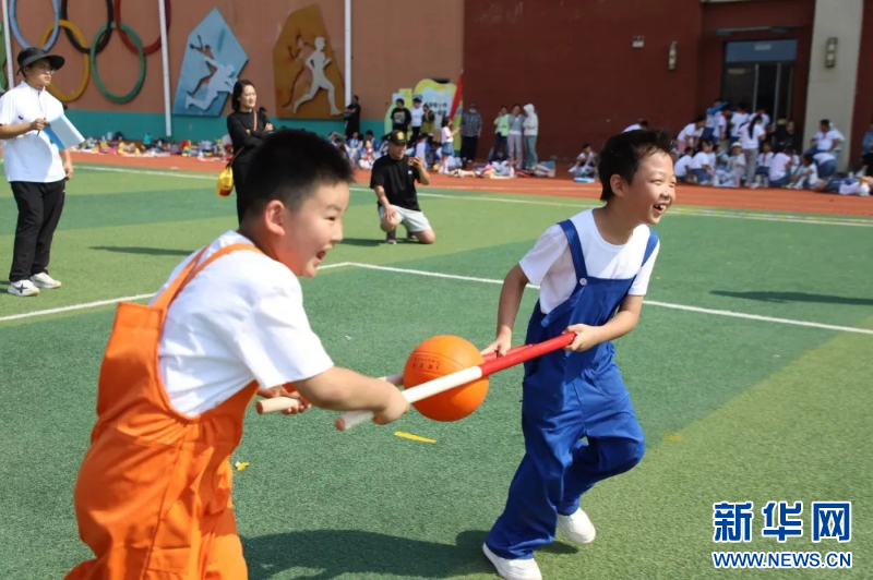 济南市市中区文贤小学的学生们接力运球，学生们在游戏中感受运动的乐趣。新华网发