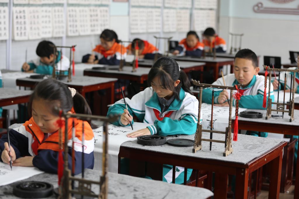 10月26日,甘肃省定西市通渭县文庙街小学的学生在书法课上写《七律·长征》。新华社发(王克贤 摄)