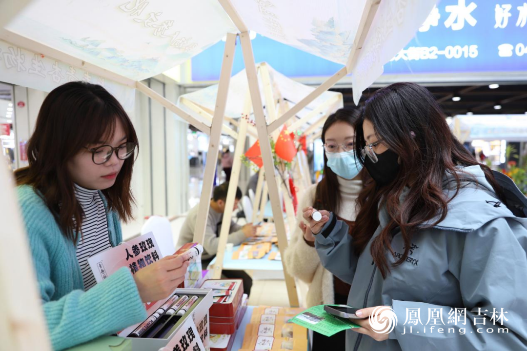 参展商、长春青杏生物科技有限公司代表苑溪桐向参观者介绍人参玫瑰饮料。