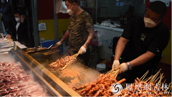 长春市桂林路商圈，商贩为食客烹饪美食。凤凰网吉林 梁琪佳摄 (动图)